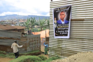 Mourners gather near a banner honoring Marie-Célestin Karondwa in Butembo